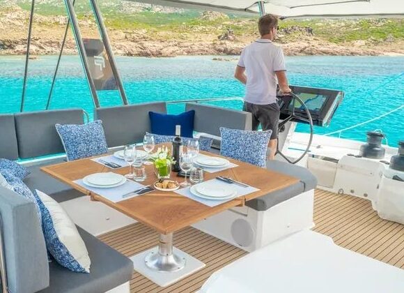 Catamaran flybridge with synthetic teak decking, set for alfresco dining
